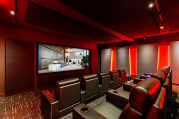 A screening room with leather chairs and a large screen